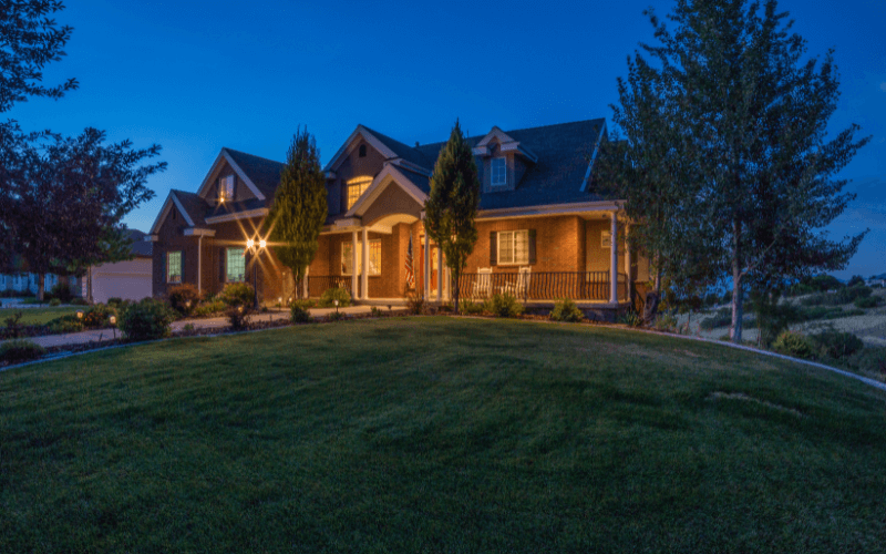  A photo of a multi-level home illuminated at dusk in the summer.