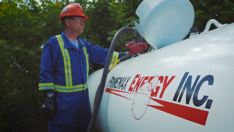 A photo of a Primemax Energy employee filling a propane tank at a residential property. 