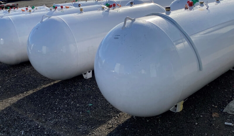 A photo of multiple propane tanks in a parking lot.