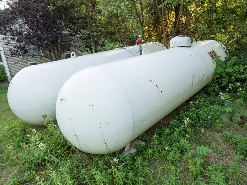 A photo of two propane tanks on grass.